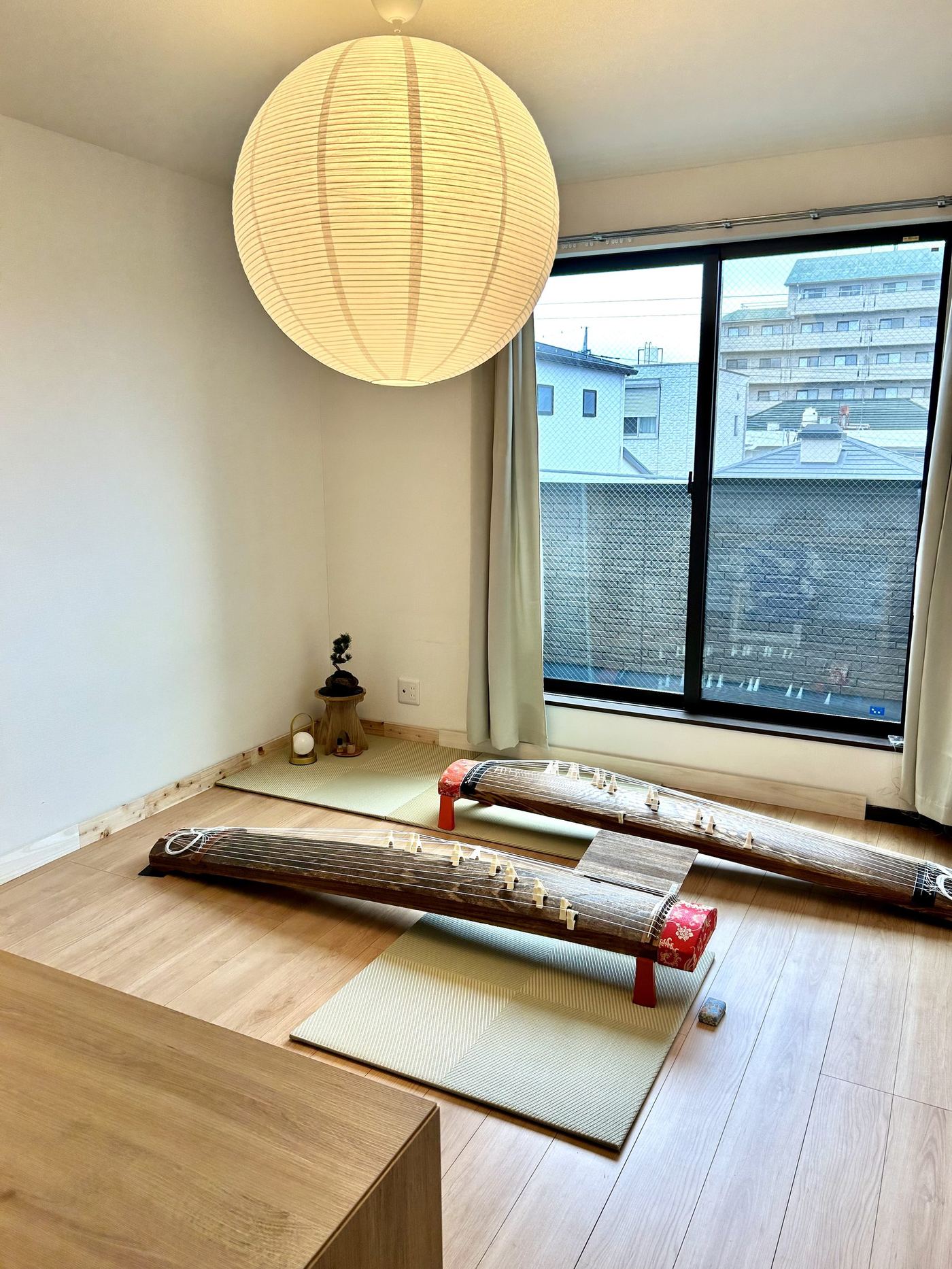 お箏教室KOKOROのお稽古場。あたたかな照明の下、畳の上に二面のお箏が並ぶ