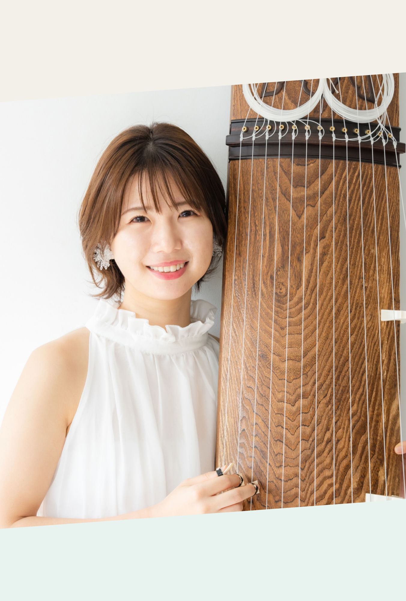 講師・細川明日香。お箏のそばで微笑むポートレート